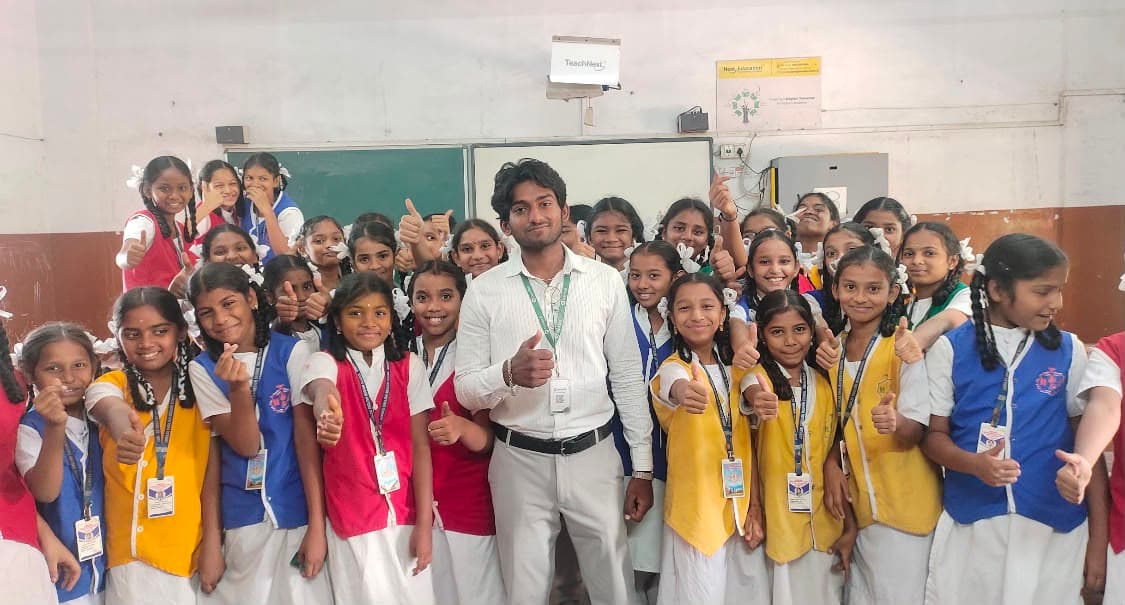 A founder surrounded by enthusiastic girls' school students — all thumbs up after an AI awareness session at their classroom.