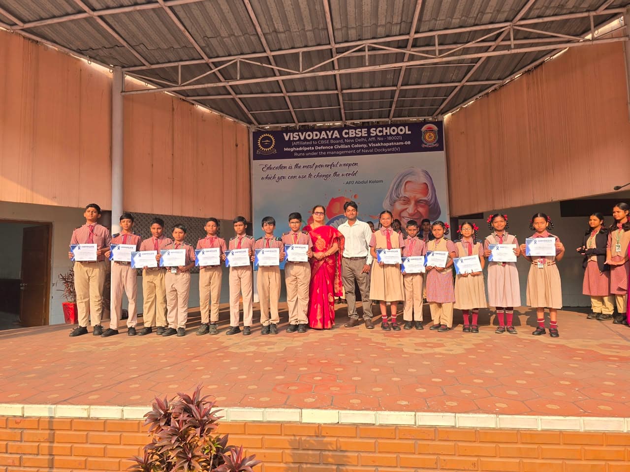 Grand certificate distribution ceremony at Visvodaya CBSE School — students lined up on stage proudly holding their NextSkill certificates alongside the school principal.